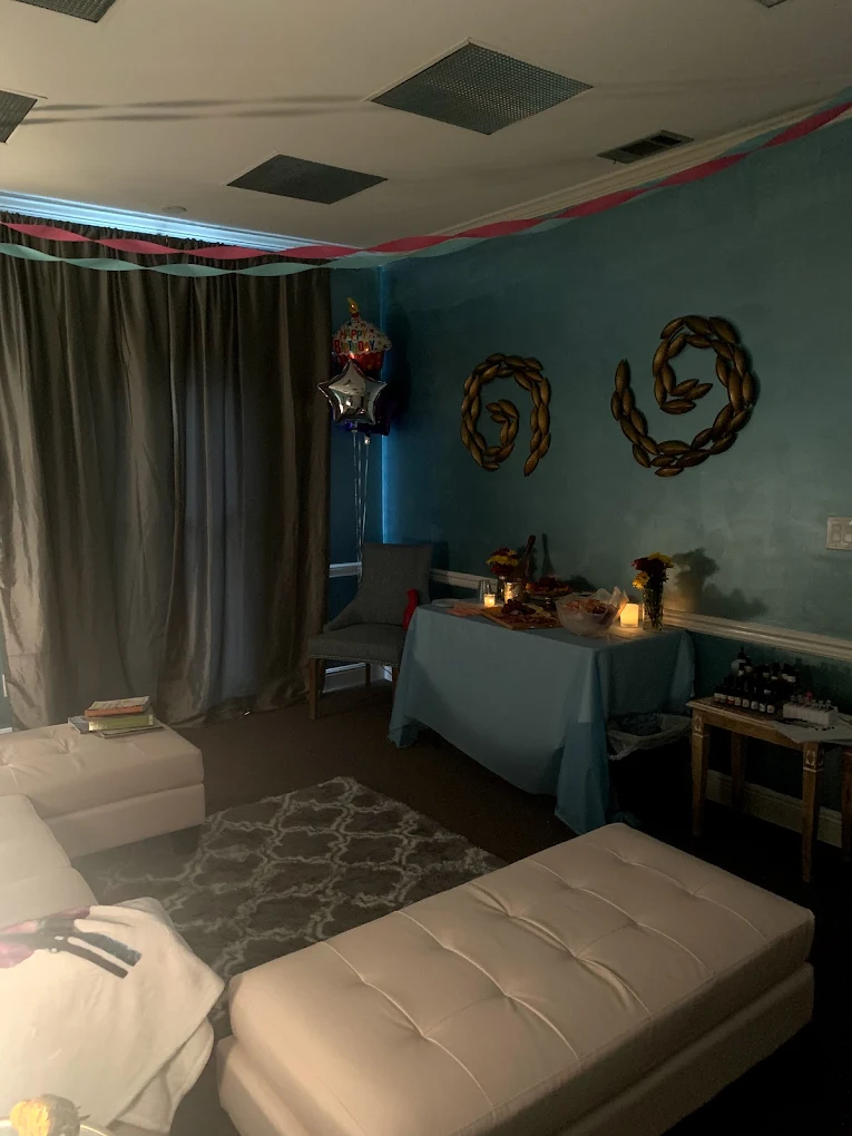 Birthday spa party setup with balloons and lounge seating