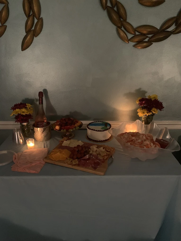 Candlelit catering spread with cake, shrimp and champagne